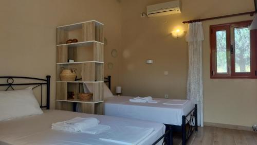 a room with two beds and a book shelf at George's Houses in Riglia
