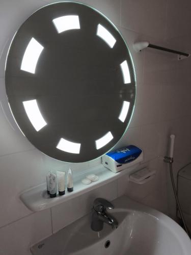 a bathroom with a large mirror above a sink at Al Rayhan Suites الريحان للأجنحة المفروشة in Al Madinah