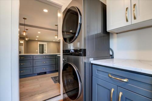 a kitchen with blue cabinets and a washer and dryer at 7BR Spacious Property Perfect For up to 15! in Orange