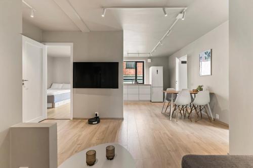 a living room with a television and a room with a bed at Heart of Tønsberg, Newly renovated, Room for 6 people! in Tønsberg