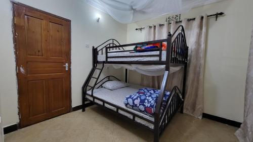 a room with two bunk beds and a door at Milele Homestay in Boma la Ngombe