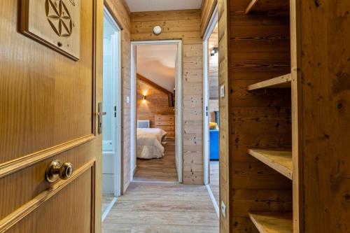 un couloir menant à une chambre dans une maison en rondins dans l'établissement Résidence Le Balcon Des Airelles - Appartement rénové avec jolie vue sur la vallée MAE-6774, aux Orres