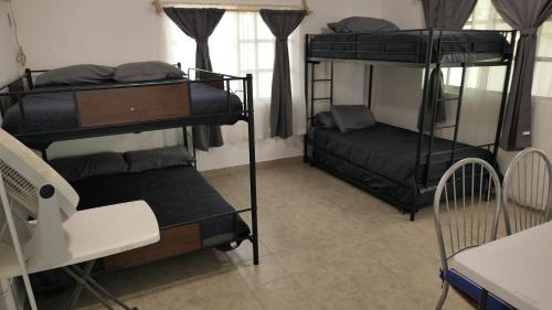 a dorm room with three bunk beds and a desk at Casa, alberca privada y jardín in Tecolutla