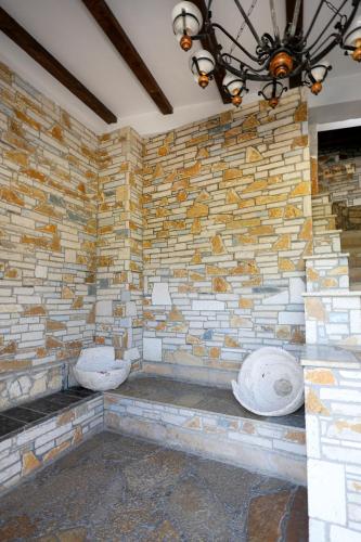 Un muro de piedra con dos baños en una habitación. en Hotel Ajka, en Berat