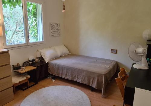 une petite chambre avec un lit et une fenêtre dans l'établissement Nature et baignades au nord de l’Hérault, à Saint-Bauzille-de-Putois