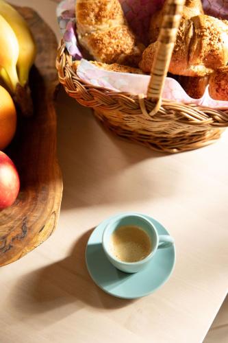 a cup of coffee next to a basket of bread at Golavškov mlin in Prebold