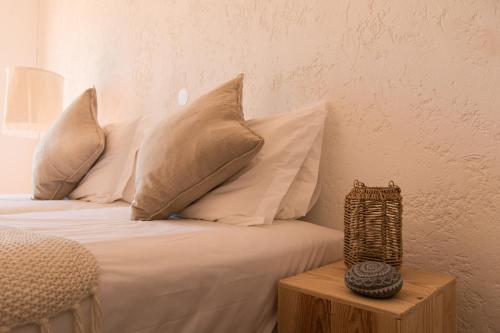 a bed with white pillows and a wooden table at Utopia in Aljezur