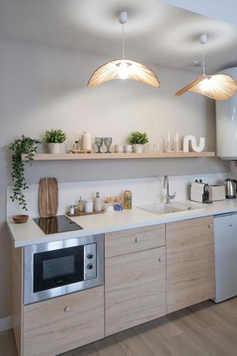 une cuisine avec un évier et un micro-ondes dans l'établissement Suite sensuelle et balnéothérapie, à Nemours