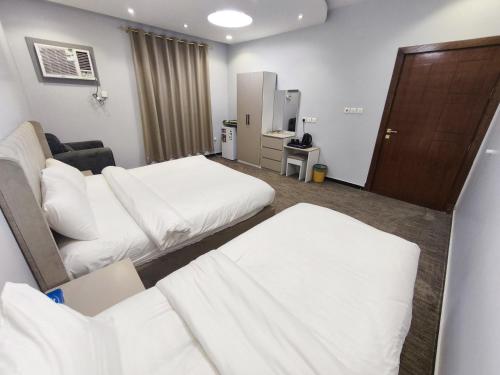 a hospital room with two beds and a couch at Al Rayhan Suites الريحان للأجنحة المفروشة in Al Madinah