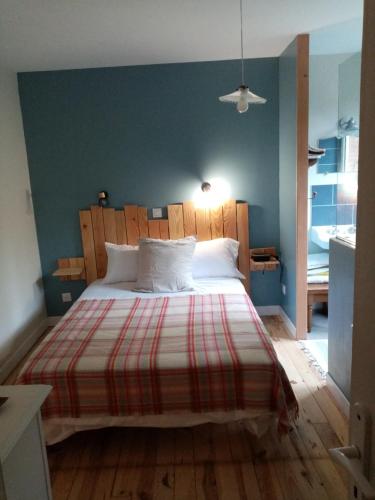 a bedroom with a large bed with a striped blanket at cosy logis et son écrin de verdure in Cordes-sur-Ciel