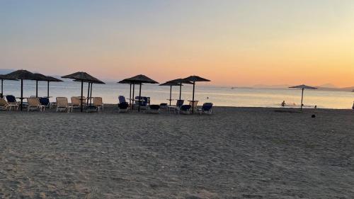 a group of chairs and umbrellas on a beach at Mina’s house in Amarinthos