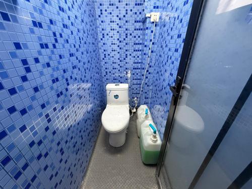 深圳Kuaike Xingjiduo Apartment的蓝色瓷砖浴室设有卫生间和坐浴盆
