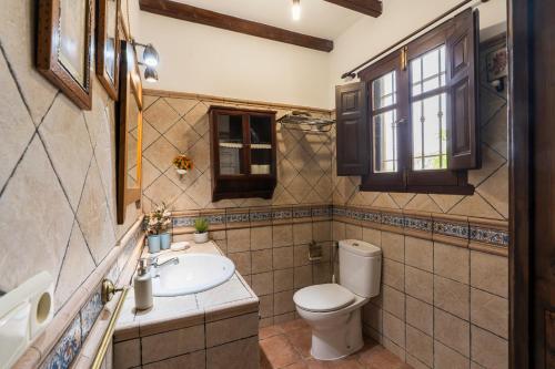 ein Badezimmer mit Toilette und Waschbecken in der Unterkunft Casa Suryta einzigartiges Landhaus bei Granada in Dúrcal