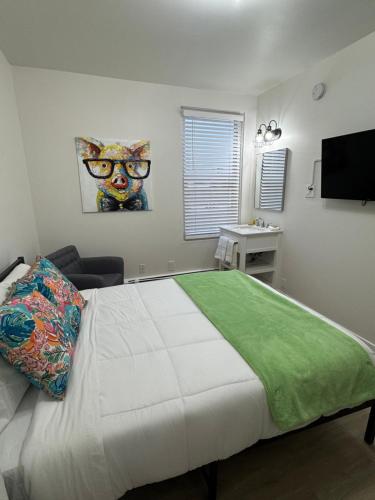 a bedroom with a bed with a cat picture on the wall at Commercial Hotel in Edmonton