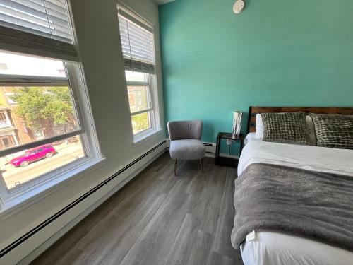 a bedroom with a bed and a chair and a window at Commercial Hotel in Edmonton
