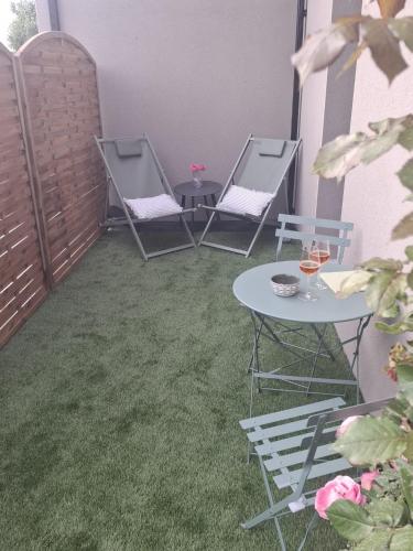 un patio avec deux tables et deux chaises et une table avec des verres dans l'établissement Ty C&K Breizh, à Plerguer