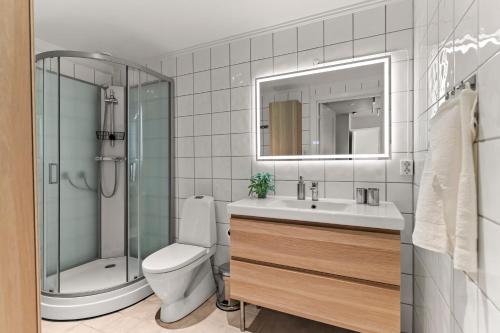 a bathroom with a toilet and a sink and a shower at Heart of Tønsberg, Newly renovated, Room for 6 people! in Tønsberg