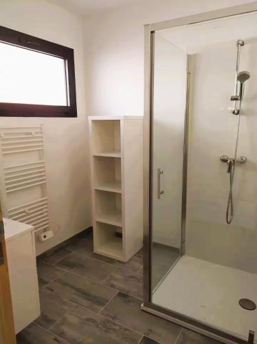 une salle de bain avec une douche avec une porte vitrée dans l'établissement Petite maison de vacances proche de la mer, à Wimereux