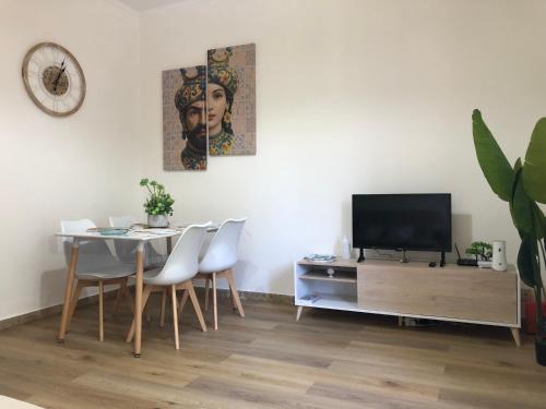 a dining room with a table and a television at Nichi & Matti Iemmolo's Guest House in Campofelice di Roccella