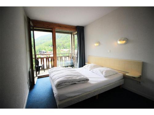 une chambre avec un lit et un balcon avec vue dans l'établissement Chalets De La Vanoise - Les Chalets de la Vanoise -CV1304- MAE-6421, à Villarodin-Bourget
