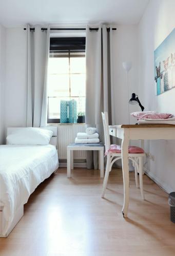 a bedroom with a bed and a desk and a window at Jül Boardinghouse in Jülich