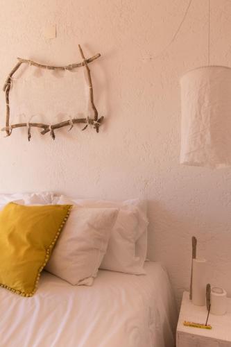 a bedroom with a bed with white pillows and a lamp at Utopia in Aljezur