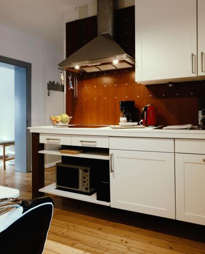 a kitchen with a white counter with a microwave at Jül Boardinghouse in Jülich