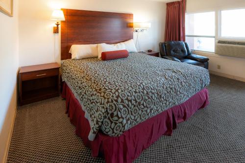 a hotel room with a bed and a chair at Hills Inn in Hot Springs