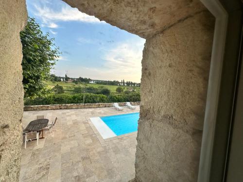 a view of a swimming pool from a window at Ancien Château viticole in Bourg-sur-Gironde