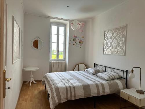 a bedroom with a bed and a table and a window at Ancien Château viticole in Bourg-sur-Gironde