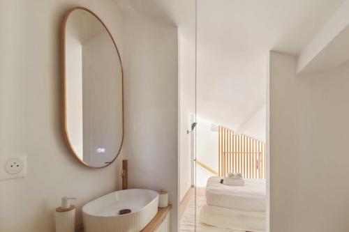 La salle de bains blanche est pourvue d'un grand miroir et d'une baignoire. dans l'établissement Cozy flat -1BDR 4P- Saint-Tropez, à Saint-Tropez