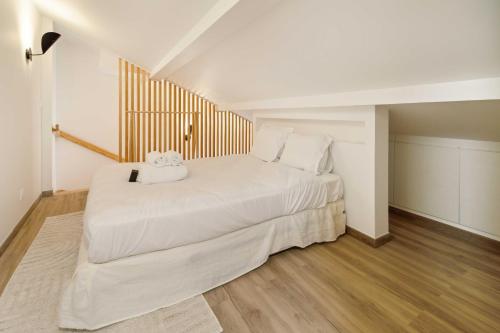 - une chambre dotée d'un grand lit blanc avec un animal rembourré dans l'établissement Cozy flat -1BDR 4P- Saint-Tropez, à Saint-Tropez