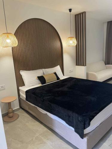 a bedroom with a large bed and a chair at Kostas Studios in Faliraki