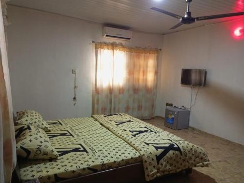 una camera da letto con un letto con piumone e cuscini di Lumsden Lodge a Benin City