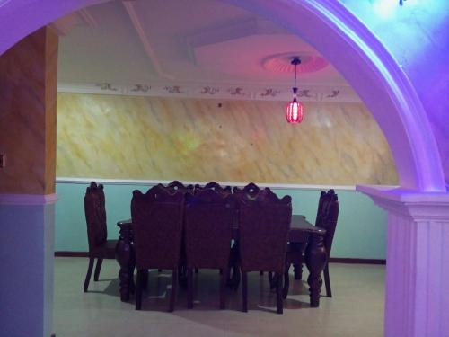 una stanza con un tavolo con sedie e una luce viola di Lumsden Lodge a Benin City
