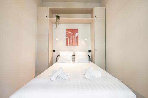 une chambre avec un lit blanc avec des oreillers blancs dans l'établissement 5 BEAUMONT - Magnifique 3P au style boheme - Quartier Garibaldi, à Nice