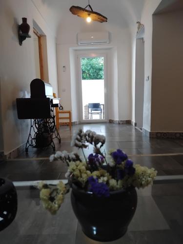 a vase of flowers on a floor with a piano at Pé na Terra Quintal in Reguengos de Monsaraz