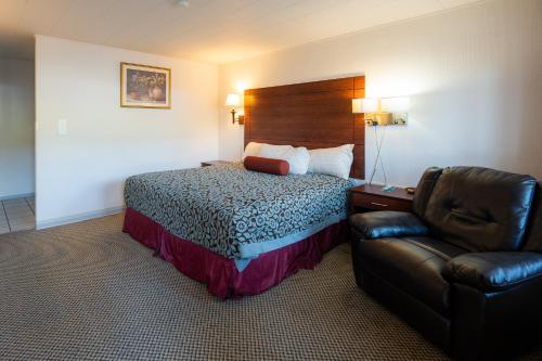 a hotel room with a bed and a chair at Hills Inn in Hot Springs