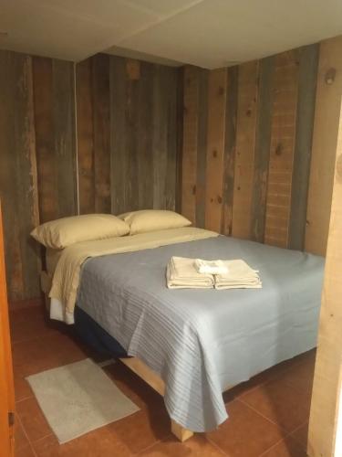 a bedroom with a bed with two towels on it at Posada Las vigas in Zacatlán