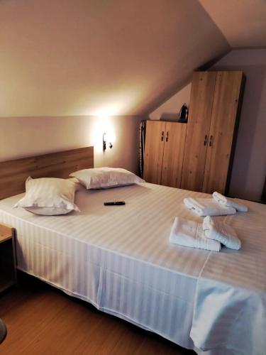 a bedroom with a large white bed with towels on it at Casa Catalyna in Predeluţ