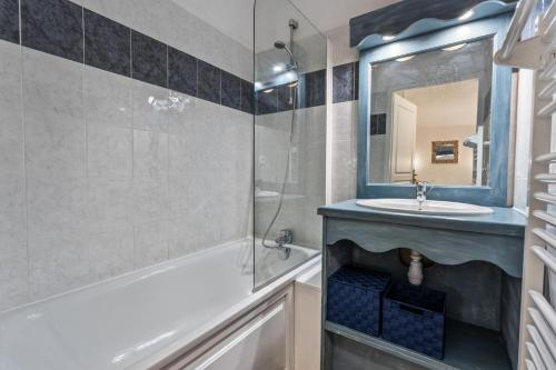 une salle de bain avec une baignoire, un lavabo et un miroir dans l'établissement Résidence Les Hauts De Preclaux - Logement pour 6 personnes avec vue sur les pistes MAE-2021, aux Orres