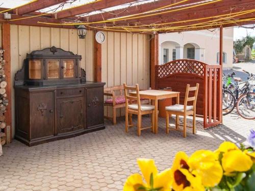 an outdoor patio with a wooden table and chairs and a table and a tablektop at Holiday apartment with 2 bedrooms in Kurort Hartha