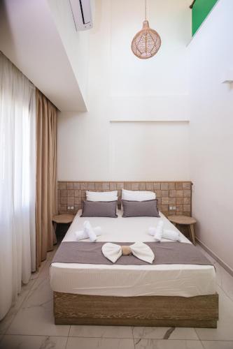 a bedroom with a large bed with two towels on it at Amalia Deluxe Villas in Nea Vrasna