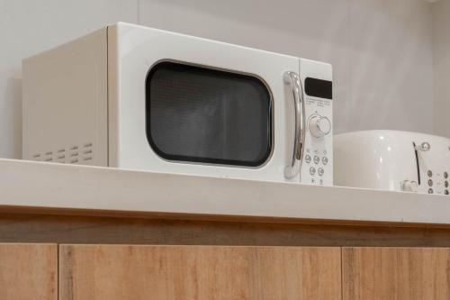 a microwave oven sitting on top of a counter at Abu Dhabi 4BR Villa - Victorian-Inspired Stay in Abu Dhabi