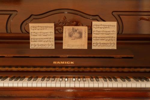 a piano with sheets of music on it at Abu Dhabi 4BR Villa - Victorian-Inspired Stay in Abu Dhabi