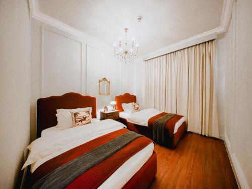 a hotel room with two beds and a chandelier at Abu Dhabi 4BR Villa - Victorian-Inspired Stay in Abu Dhabi
