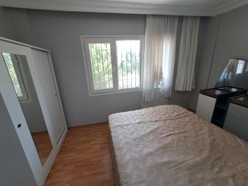a bedroom with a bed and a window and a mirror at Kuşadası Starfish in Kusadası