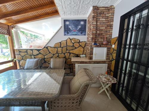 a dining room with a stone wall and a table and chairs at Kuşadası Starfish in Kusadası