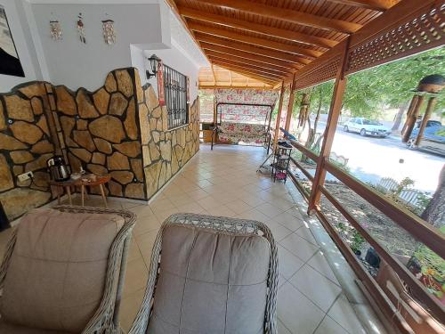 a living room with two chairs and a stone wall at Kuşadası Starfish in Kusadası