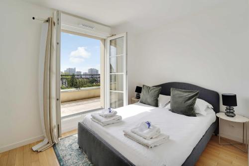 une chambre avec un lit et une grande fenêtre dans l'établissement Superb 3BR with Terraces – Puteaux La Défense, à Puteaux